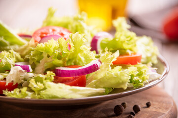 Green vegetable salad with lattuce, tomatos, onion. Healthy food concept