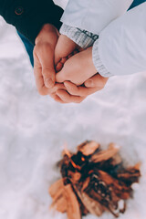 Man warms hands of a woman in his hands. winter hike theme