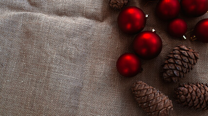Christmas composition. Sustainable decor. Zero waste flat lay. Copy space. Christmas toys and pine cones on burlap background. Eco-friendly New Year or Christmas concept.