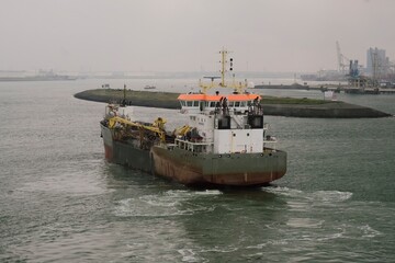 Fototapeta premium Port of Rotterdam, the Netherlands - 09 20 2020: Dutch-flagged suction dredger during seabed dredging operations in the port.