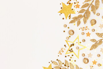 Frame made from gold colored glittering decorations on a white background.