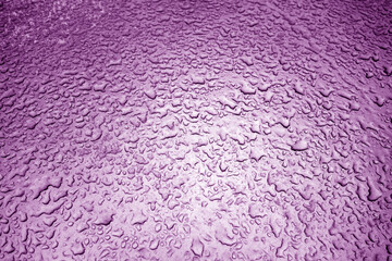 Water drops on metal surface in purple tone.
