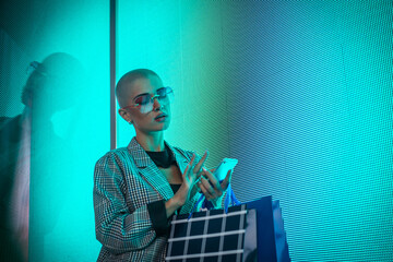 Image of a beautiful young woman posing against a led panel.