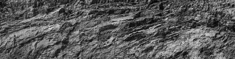 Grungy cragged bumpy pitted cavity stone facade, split layer gap.Ruined cracked shattered worn rough hiking canyon.Old ragged grunge steep marble cliff. Grand vintage crannied damaged impressive gorge
