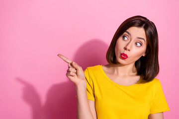 Fototapeta na wymiar Photo of charming funny young woman wear yellow outfit lips pouted pointing empty space isolated pink color background