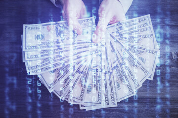 Multi exposure of technology drawing hologram and us dollars bills and man hands. Data concept