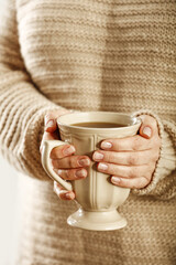 Woman hands and mug with hot drink 