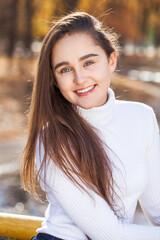  young brunette girl posing in autumn park