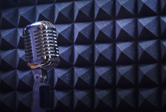 Old fashion mic, in an isolated recording studio booth. Retro professional equipment on a music template, with copy space for text