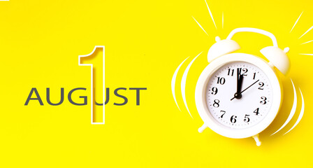 August 1st . Day 1 of month, Calendar date. White alarm clock with calendar day on yellow background. Minimalistic concept of time, deadline. Summer month, day of the year concept.