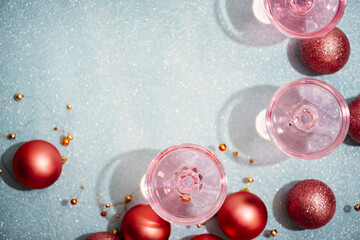 Pink champagne in crystal glasses on shiny mint blur background. New year celebration party with...