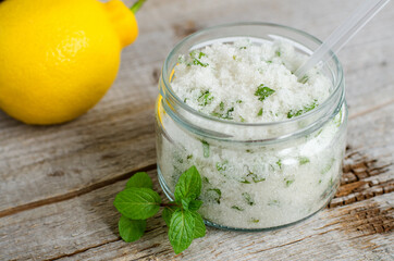 Homemade mint exfoliating scrub (scalp peeling, bath salt, foot soak) with sugar, chopped mint leaves, lemon juice and essential mint oil. Natural skin and hair care. DIY beauty treatments, spa recipe
