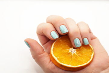 A woman's hand with a nude mint manicure and a pattern in the form of a Christmas tree