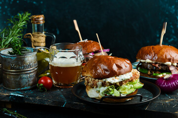 Street food. Homemade burger or burger with fresh vegetables and cheese. On a dark background.