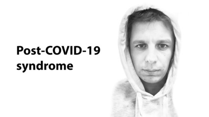 Portrait of a sad Caucasian Man of 36 year in a Hood with the inscription Post Covid 19 Syndrome. Sad devastated weary man with neurological disorders in the recovery period after covid illness.