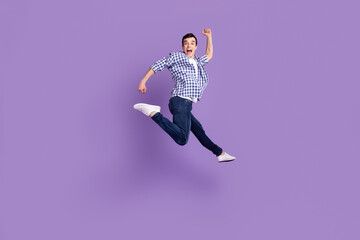 Fototapeta na wymiar Full size profile side photo of young excited man go walk run jump up air isolated over purple color background