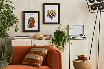 Creative interior composition of living room with designed couch, two mock up poster frames, coffee...