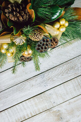 Wood table background with Christmas decoration including pine branches and pine cones. Merry Christmas and happy new year concept. Top view with copy space, flat lay.