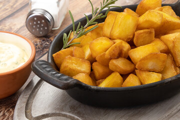 pommes de terre frites avec romarin et sauce sur fond de bois