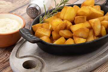 pommes de terre frites avec romarin et sauce sur fond de bois