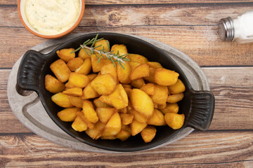 pommes de terre frites avec romarin et sauce sur fond de bois