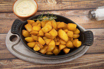 pommes de terre frites avec romarin et sauce sur fond de bois