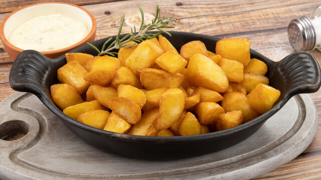 pommes de terre frites avec romarin et sauce sur fond de bois