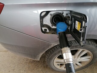 Transport and industry concept. Refilling the car. A refueling valve is inserted into the fuel filler neck.