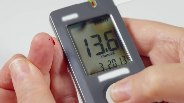 Diabetic checking their blood glucose levels on a glucometer