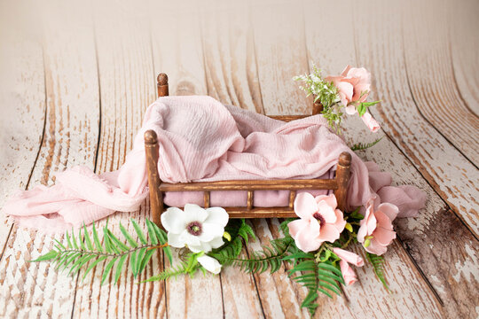 baby white bed for newborn photo shoot. props for a photo shoot. the bed is decorated with flowers. furniture for dolls and magnolia flowers