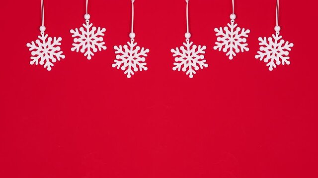 Hanging snowflakes on red theme. Christmas decorations stop motion
