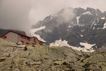 Riese in den Wolken; Monte Disgrazia (3678m), davor das Rifugio Ponti auf 2559m (Bernina-Alpen)