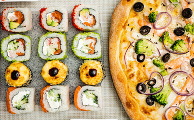A beautiful set of sushi with pizza. View from above