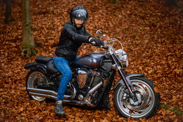 Fototapeta premium Handsome biker in the forest in autumn.