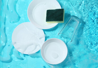 Dishware and sponge in clean water.
