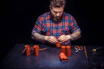 Tanner of leather cutting out leather goods in his leather studio