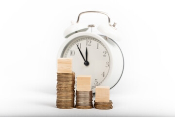 growing pile of money and alarm clock. economy and tax concept. isolated white background.