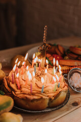 closeup birthday apple pie with burning candles and candle number one. marshmallows, gingerbread, apple pie, charlotte. healthy homemade sweets and fruits are on a wooden table. High quality photo