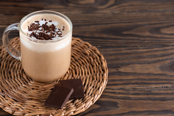 Moccacino coffee on coconut milk with chocolate on a wooden table. Horizontal orientation, copy...