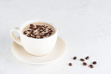 Moccachino coffee with nuts and chocolate on a light background.