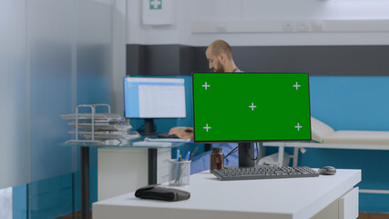 Multi-ethnic team discussing sickness symptoms analyzing medical document working at healthcare treatment in hospital office. Mock up green screen chroma key computer with isolated display