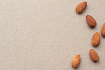 縦に並べたアーモンドとテクスチャのあるグレーの背景とコピースペースの俯瞰カット