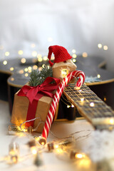 guitar surrounded by lights garlands with a present, gingerbread house and striped candy. cozy...