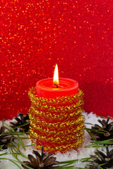 Burning candle in the snow in Christmas decoration
