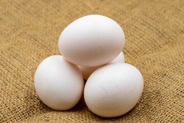 Egg carton on jute fabric. close-up white egg. horizontal view