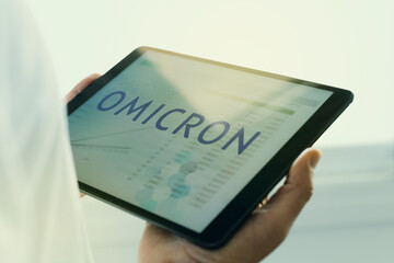 doctor and text omicron in a tablet
