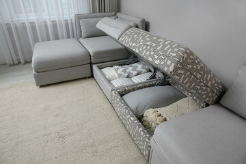 Modular sofa with storage near wall in living room. Interior design