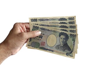 Human hand holding several jpy bills on white background.
