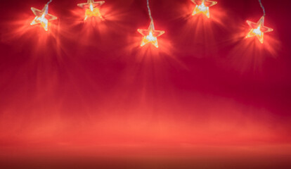  string of bright orange stars. Red background. Christmas decoration