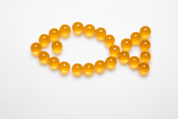 fish laid out from omega 3 fish oil capsules 